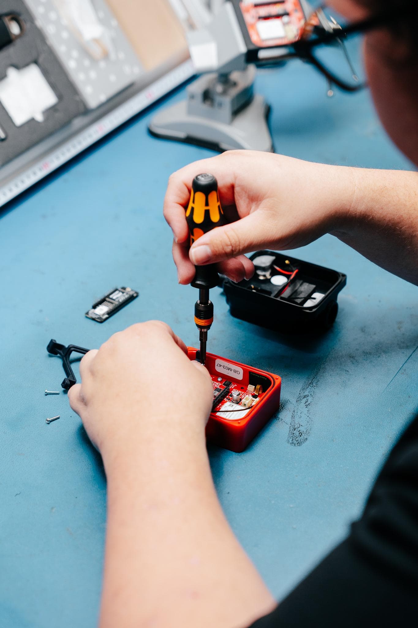 A technician assembling an electronic product enclosure on the bench